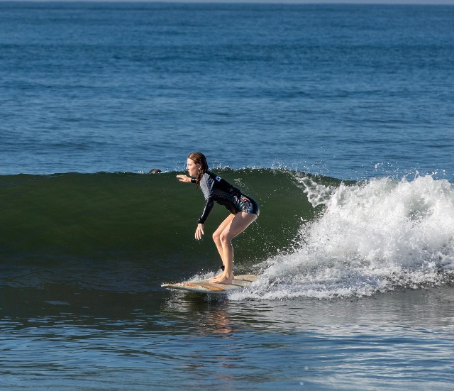 Sierra Pacific surfing on a longboard. Trimming on a shoulder high right. Sierra Pacific surfing on a longboard. Trimming on a shoulder high right.